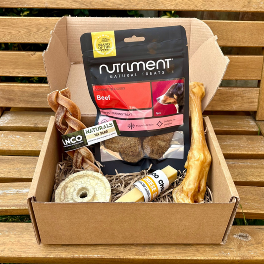 Box of dog treats and chews with Nutriment packaging on a wooden surface