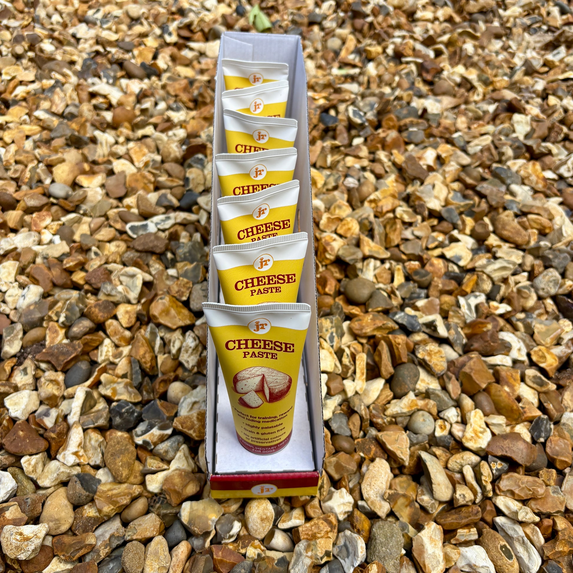 Pack of cheese paste packets on a gravel background