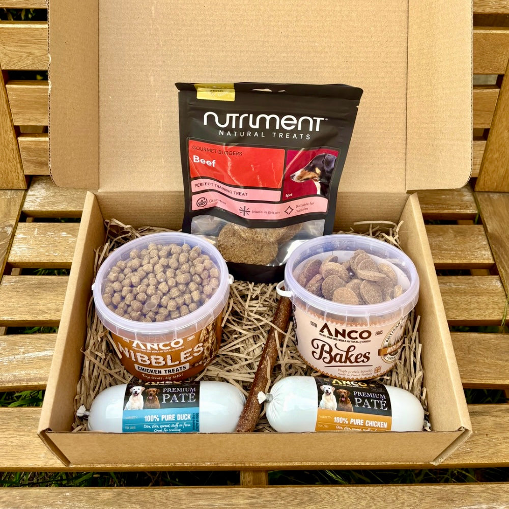 Dog treat and food products in a box on a wooden surface