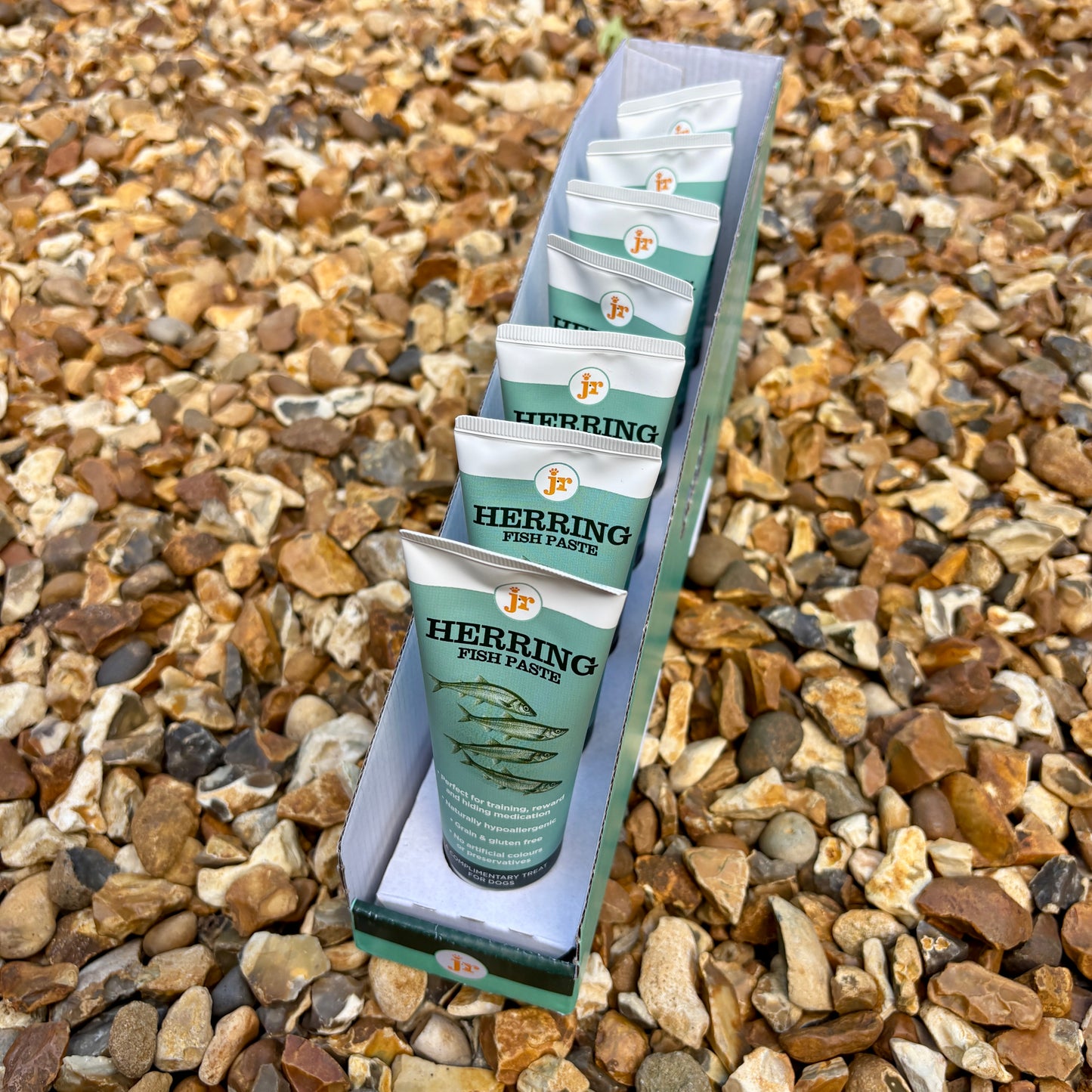 Packaged herring fish paste on a bed of small stones