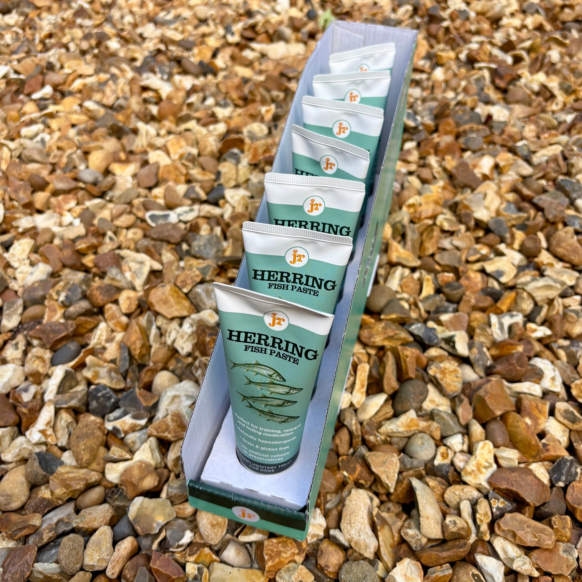 Packaged herring fish paste on a bed of small stones