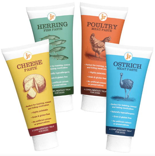Four tubes of different flavors of pet paste on a white background