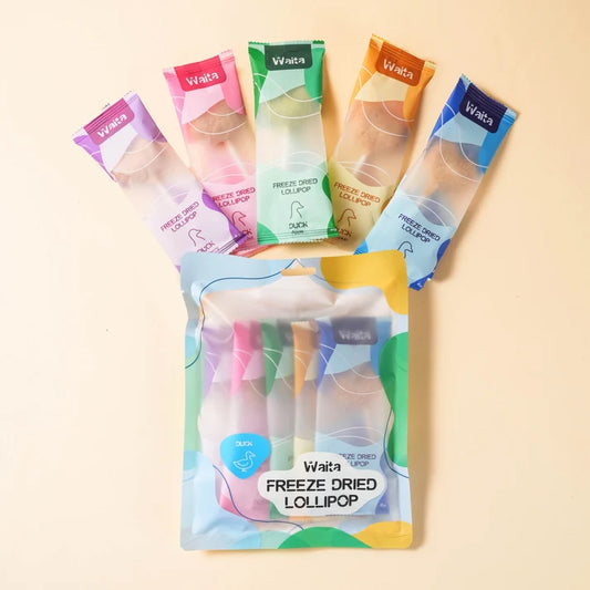 A package of Waita freeze dried lollipop with five individual packets fanned out behind it on a light beige background. The packets are in pink, purple, green, orange, and blue flavors, and the front package shows two colorful lollipops inside.